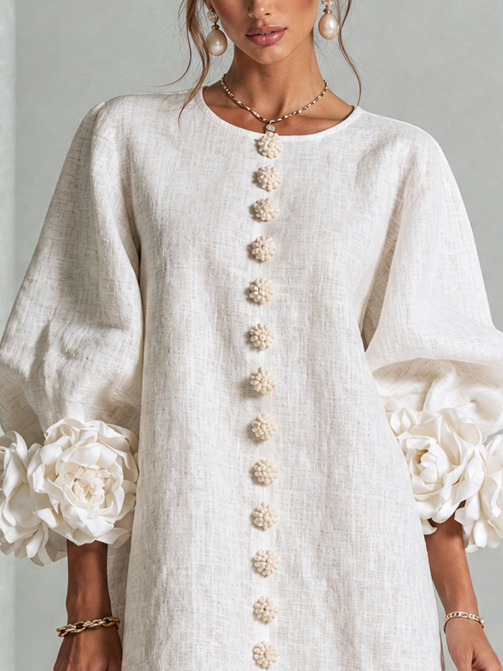 Mini-robe blanche à boutons en forme de fleurs et manches florales extravagantes